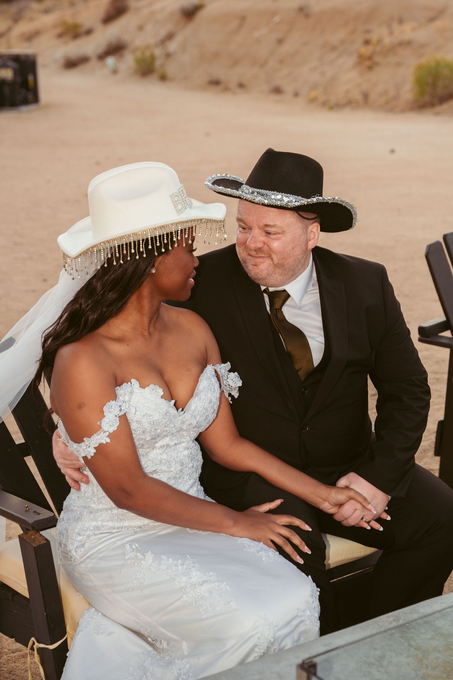 A wedding couple sharing a tender moment outdoors in western-style attire.