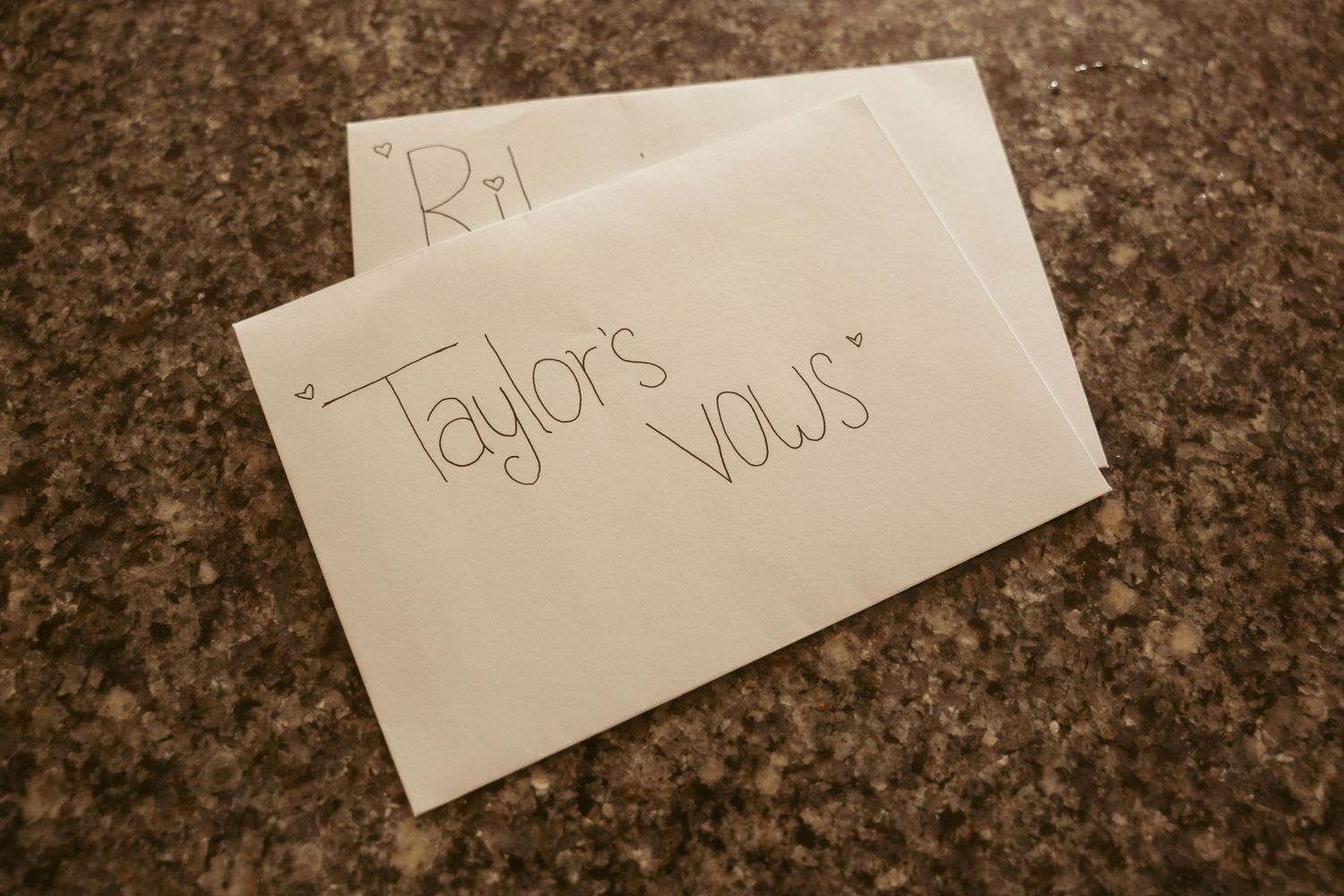 Handwritten name cards placed on a dark granite countertop surface.