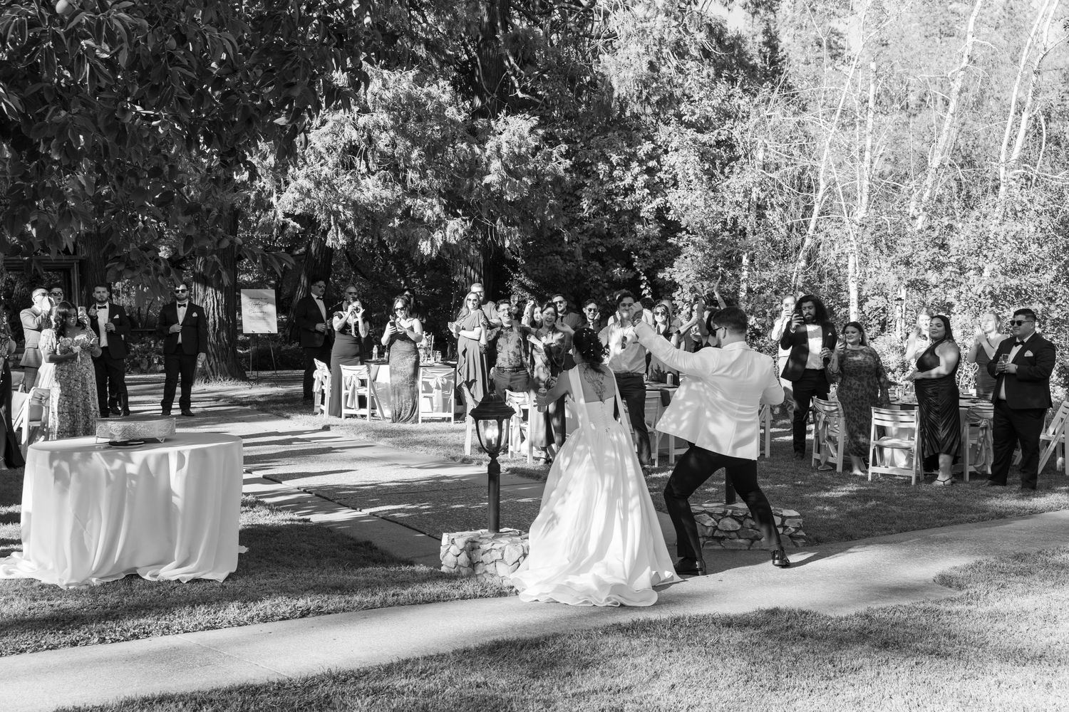 Black and white photo of wedding reception guests mingling outdoors.