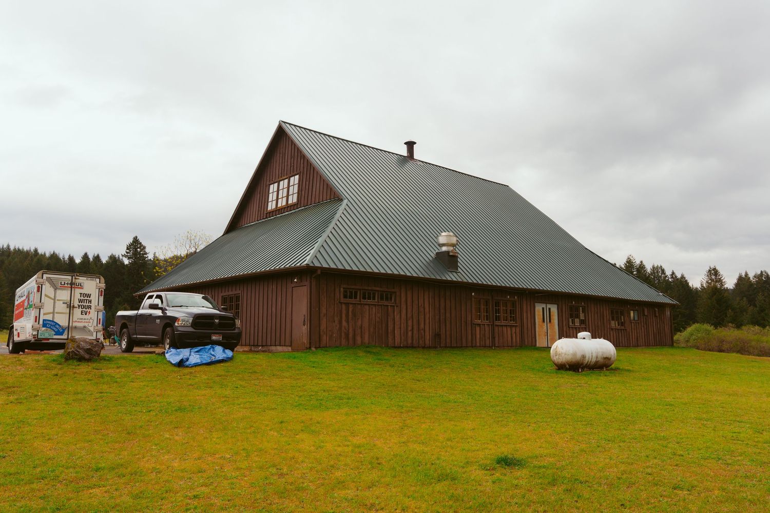 Panoramic view of a rustic barn venue set on a green hillside.