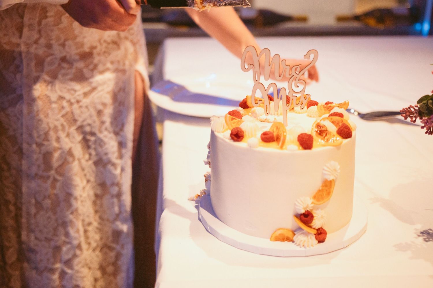 Wedding cake display with delicate decorations and soft lighting.