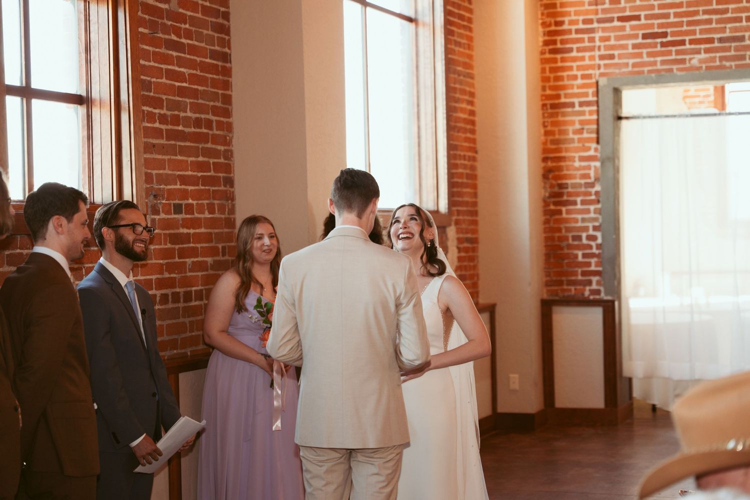 Wedding celebration in progress within historic brick venue with natural light.