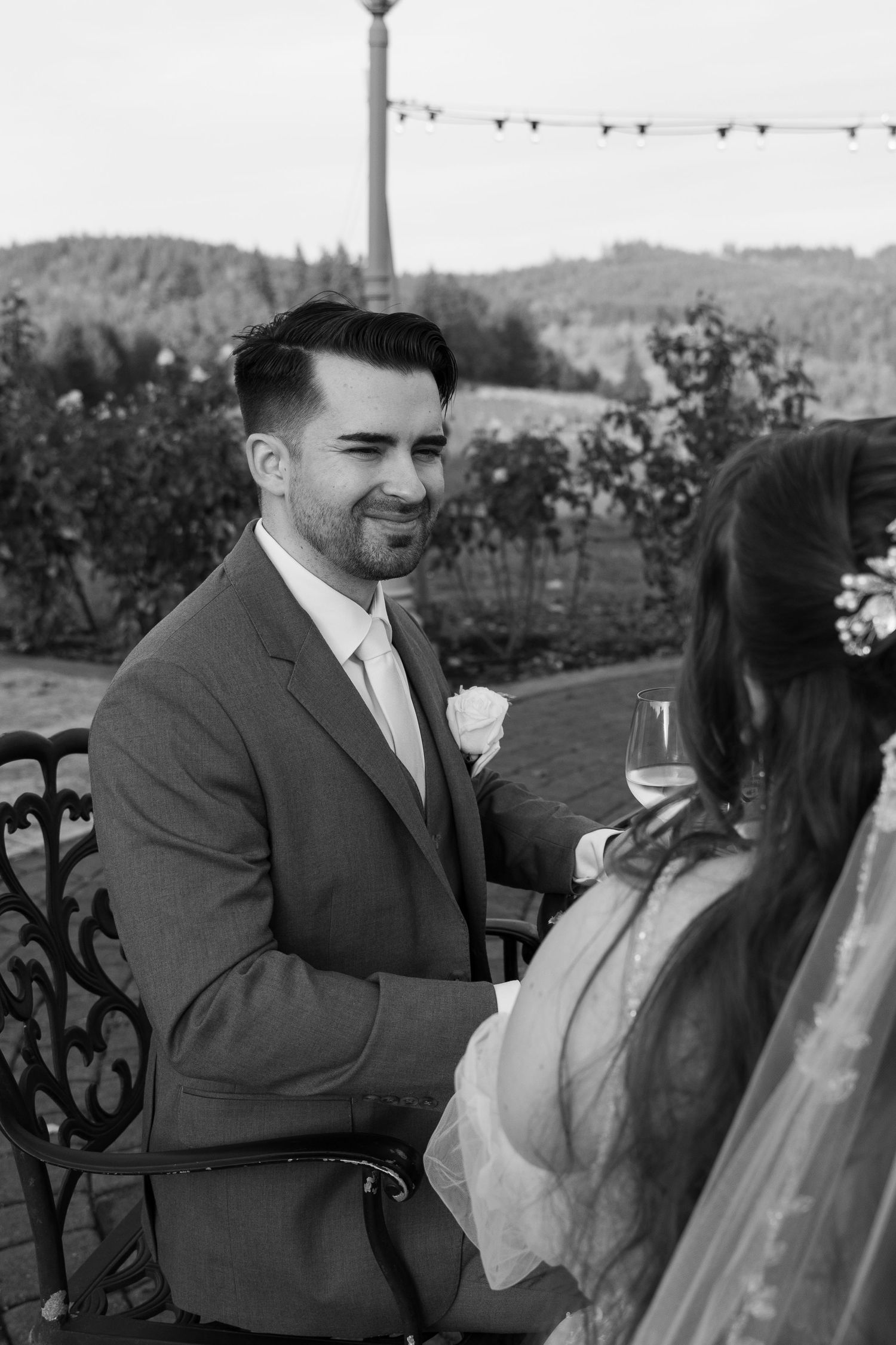 A couple sits together on a patio overlooking scenic mountain views at dusk.
