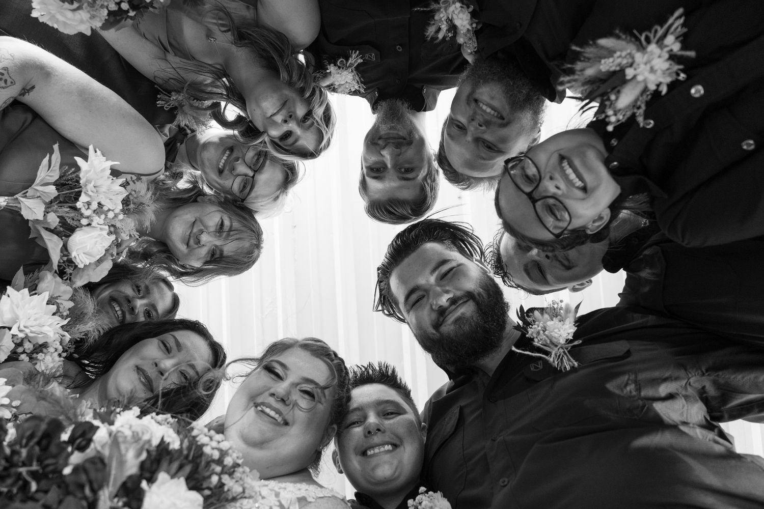 Black and white circular group photo showing wedding party members in festive poses.