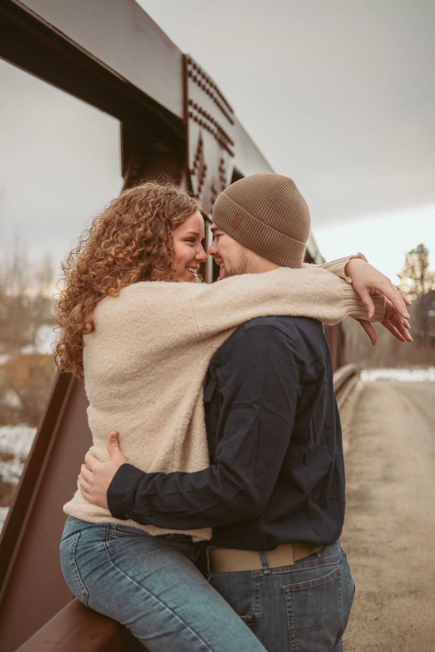 A tender embrace captured in warm tones against a mountain backdrop.