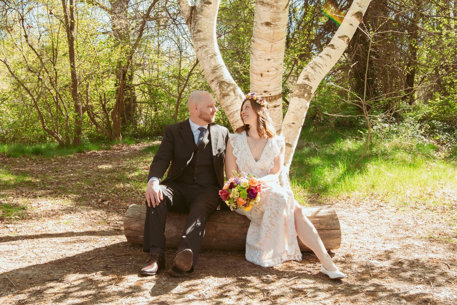 Wedding portraits in a natural woodland setting with birch trees and dappled sunlight.