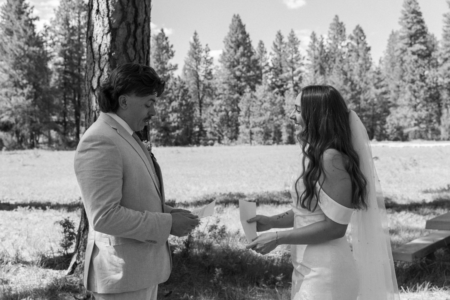 A black and white capture of a wedding ceremony moment in a pine forest.
