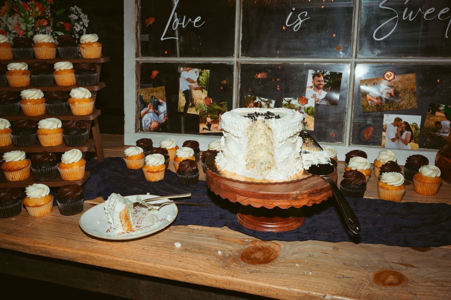 Dessert table with cupcakes and cake displays at a wedding reception.