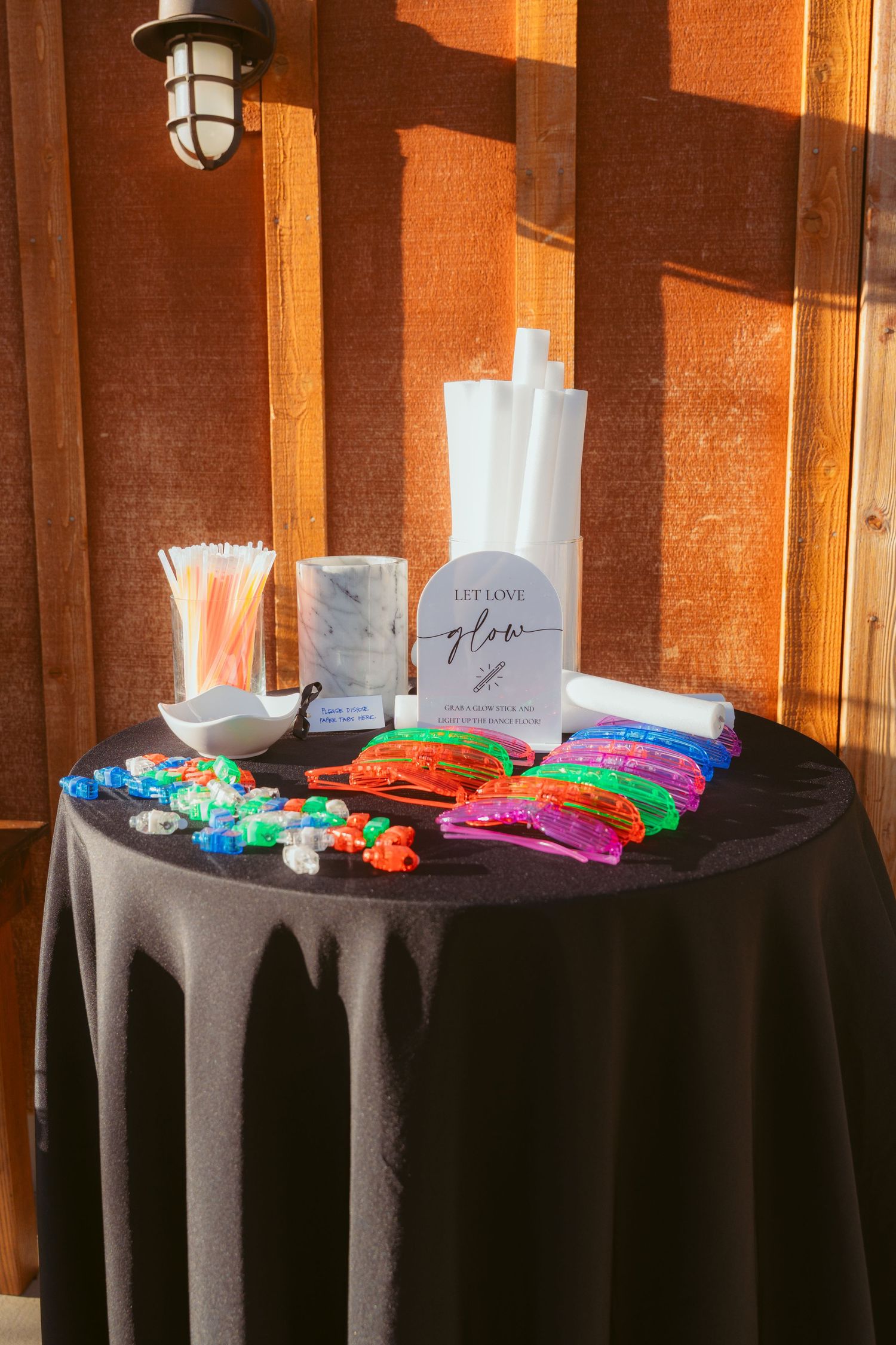 Wedding favor table with black tablecloth displaying colorful gifts and party favors.