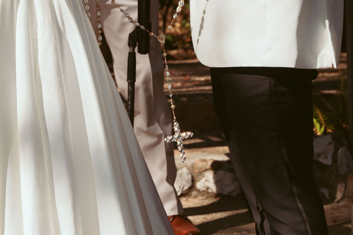 A close-up detail shot of wedding attire during an outdoor ceremony.