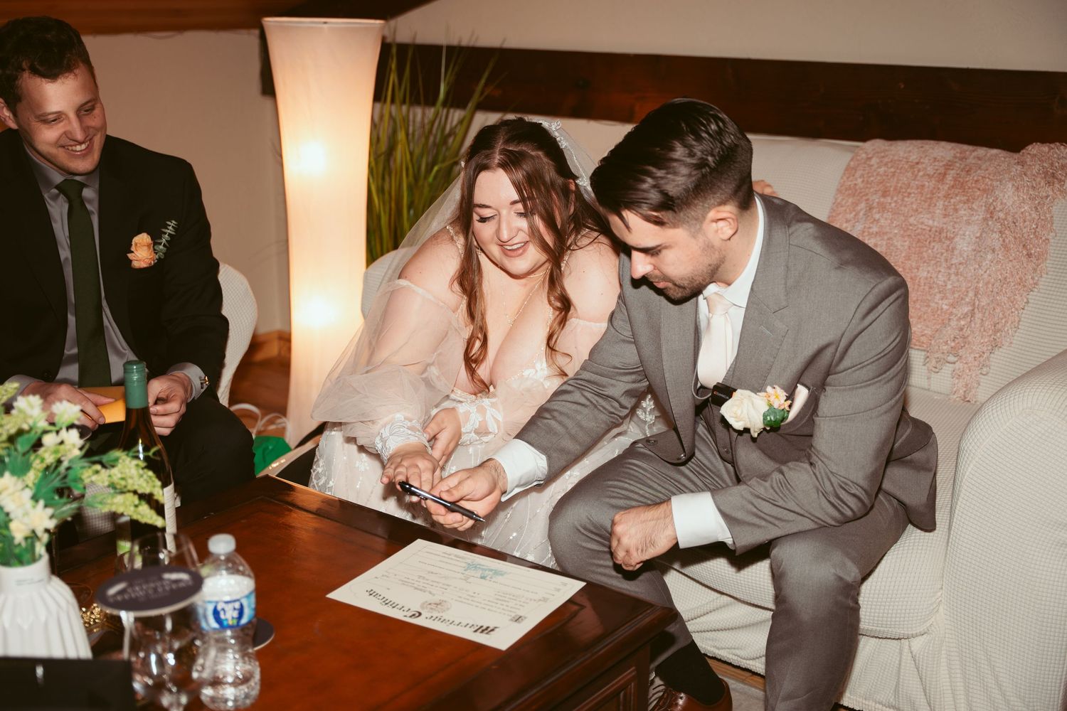 Wedding ceremony paperwork being signed at reception with warm lighting.