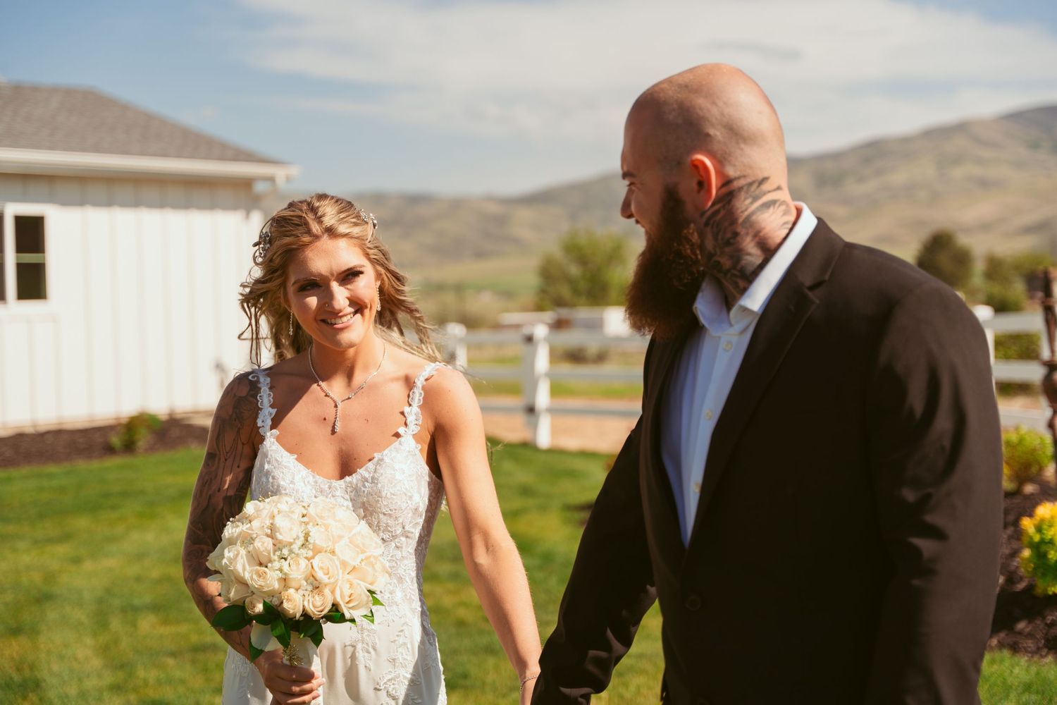 A couple shares an intimate moment in front of a scenic mountain landscape on their wedding day.