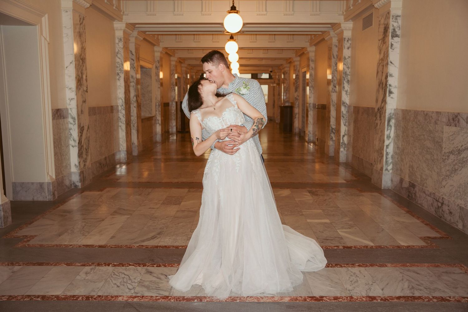 Dancing in an elegant hallway with ornate architectural details and warm lighting.