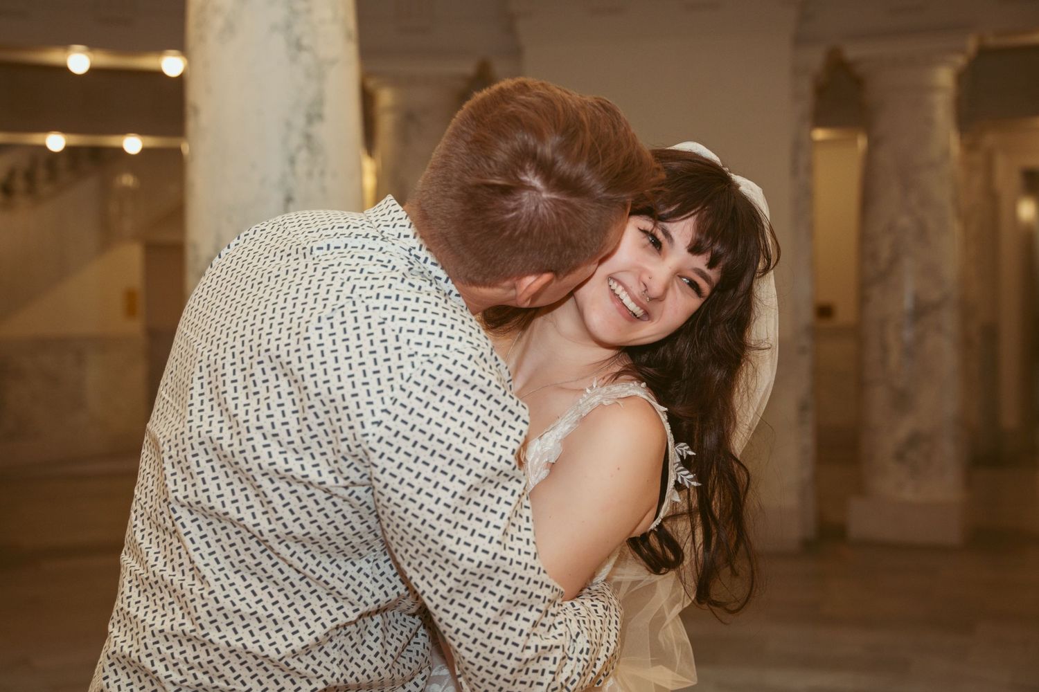 Couple shares a romantic dance moment in an indoor venue with warm lighting.