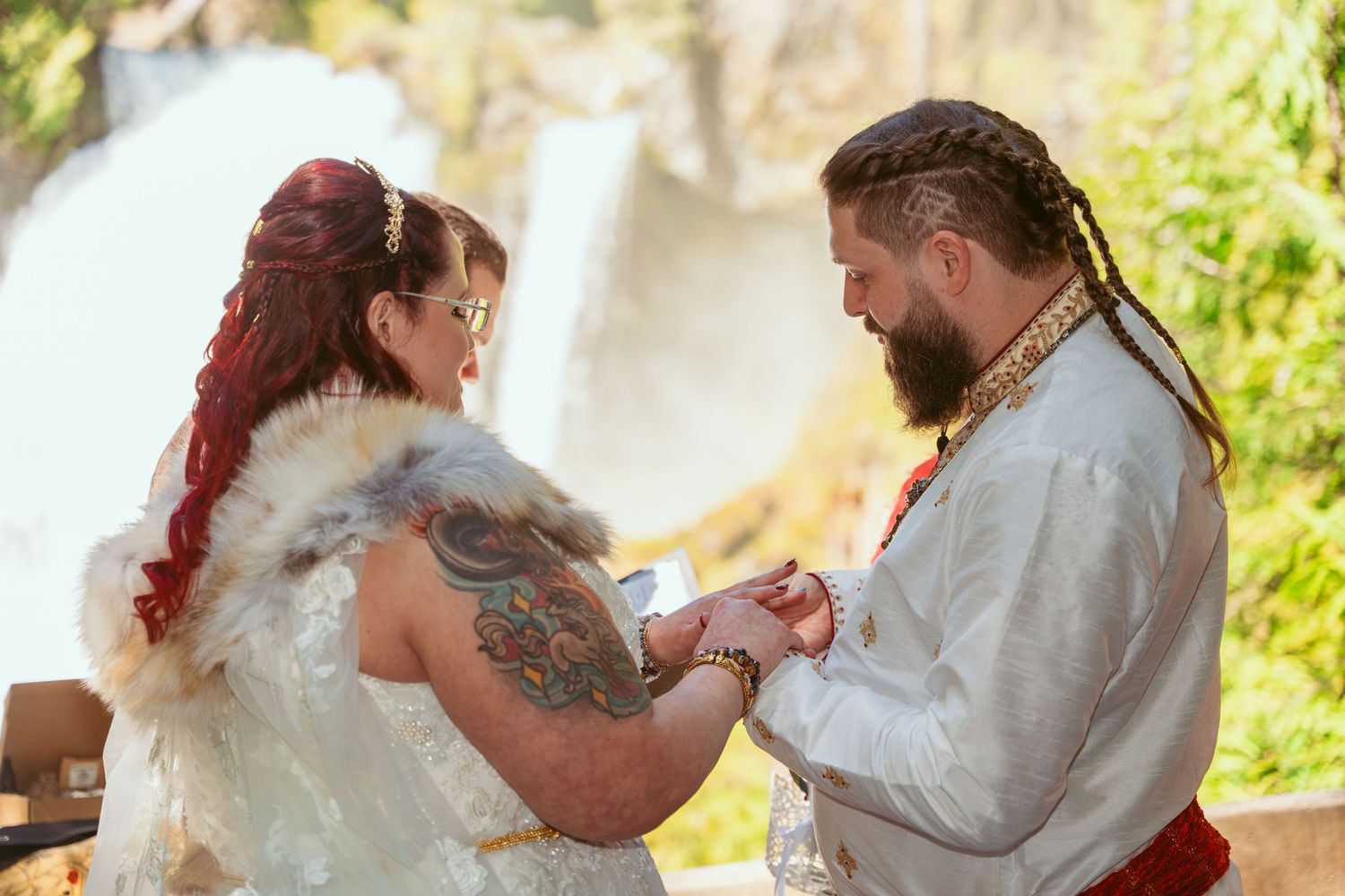 A couple embraces during their wedding photoshoot in a sunlit outdoor setting.
