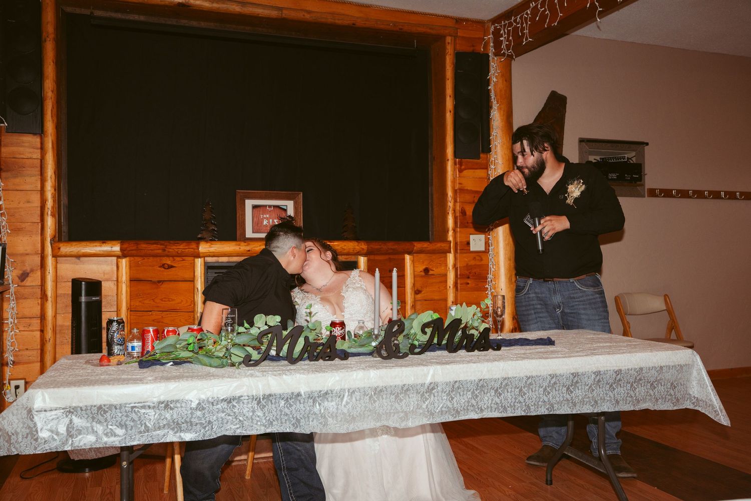 Wedding reception setup in a rustic wooden lodge with decorated tables and ambient lighting.