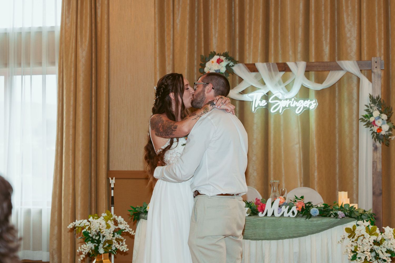 Wedding reception venue decorated with elegant draping and soft lighting.