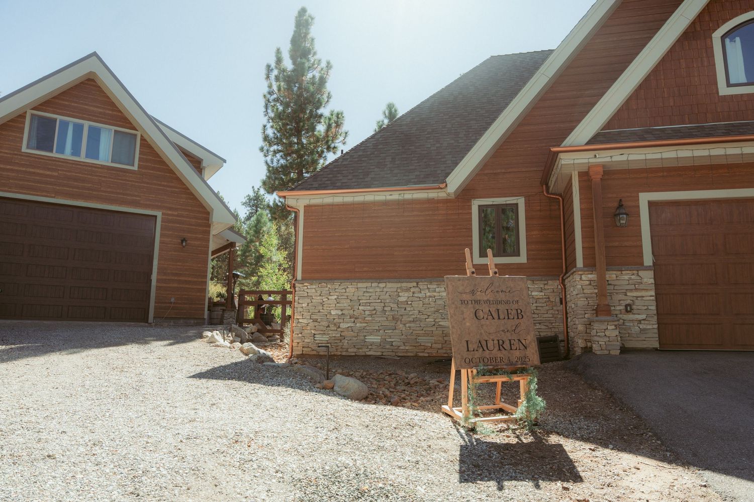 Rustic wooden cabin exterior with stone accents and landscaping in a mountain setting.
