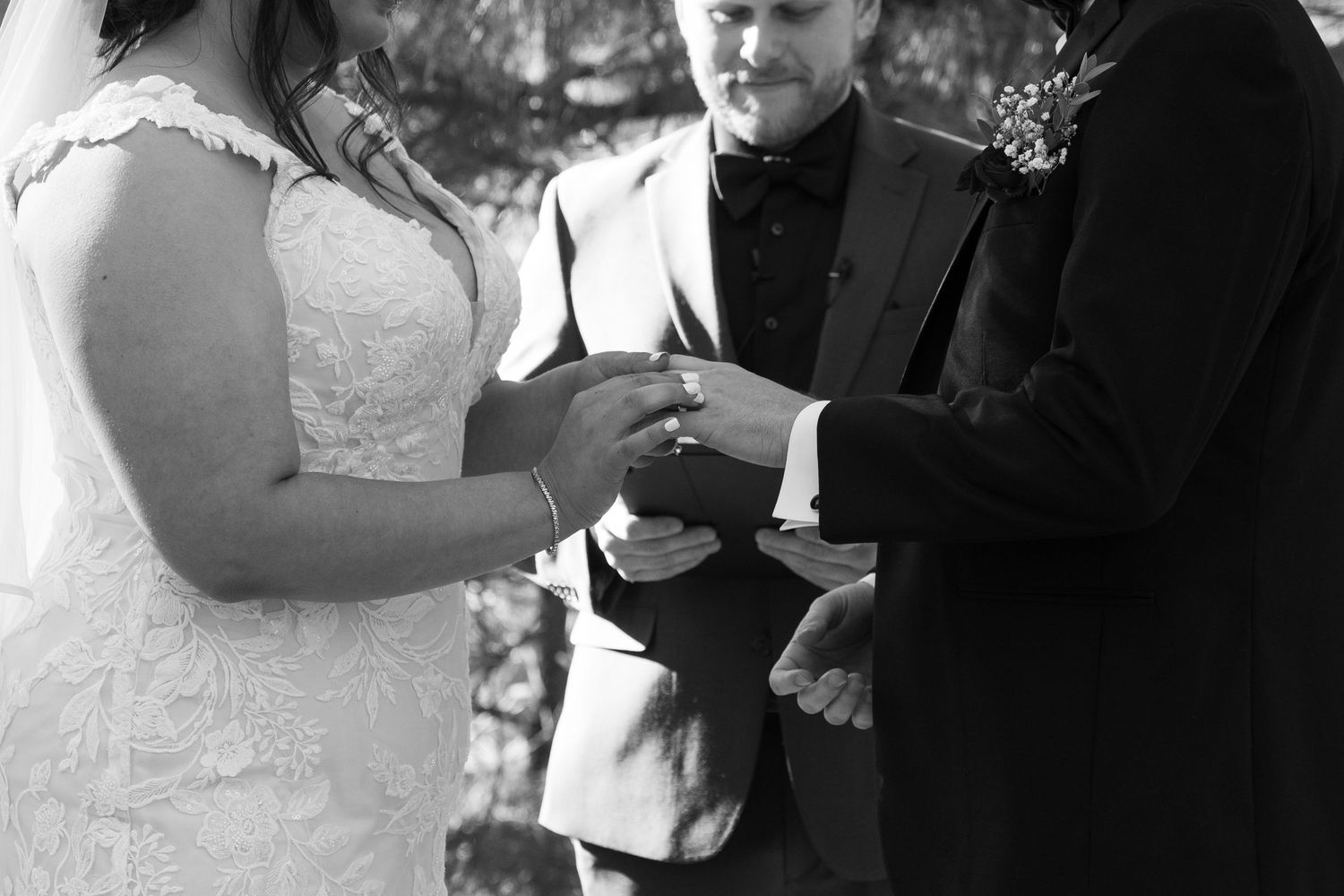 Close-up shots of a wedding ceremony showing hands exchanging rings under a fabric canopy.
