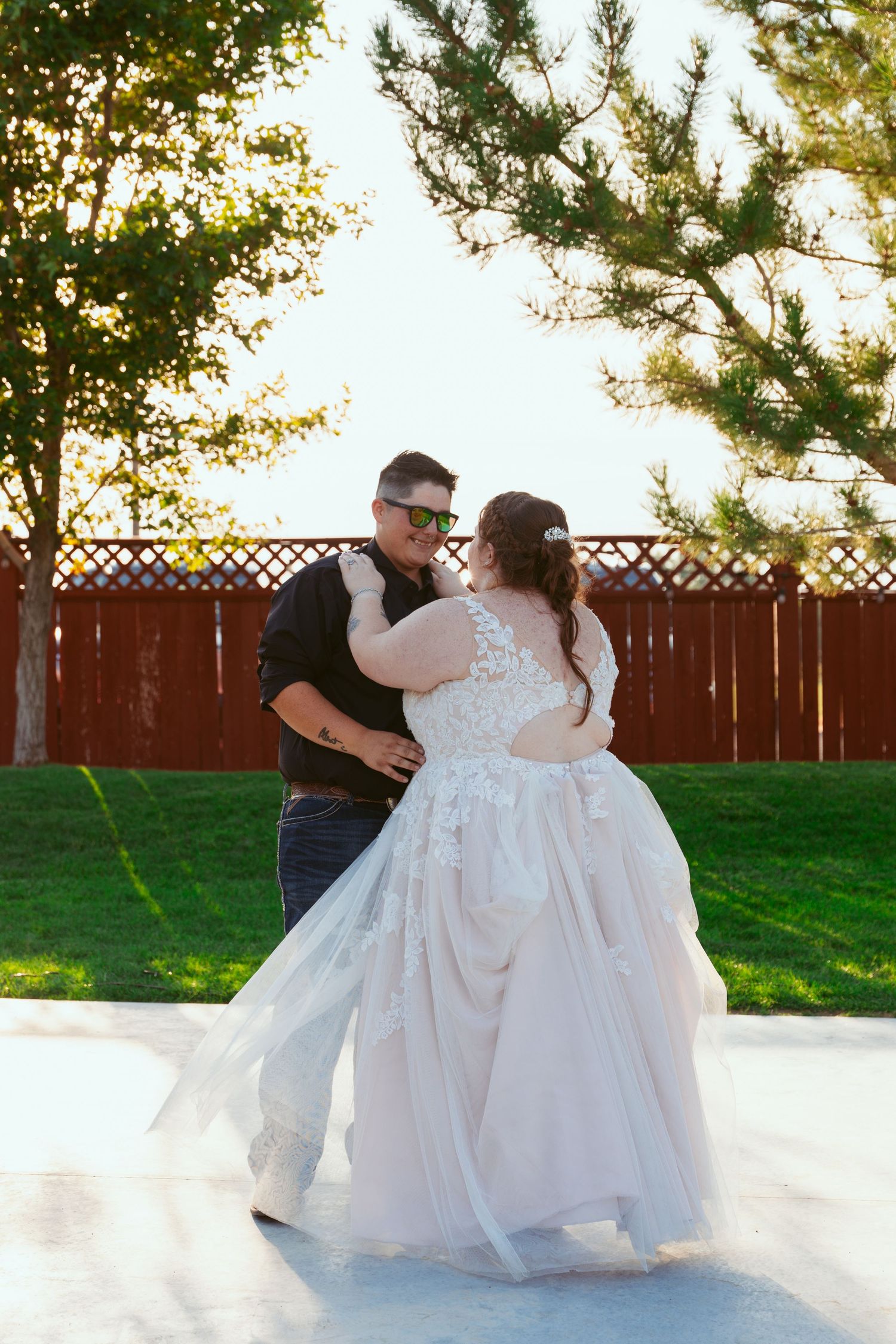 A couple shares a romantic dance moment on an outdoor dance floor at their wedding.