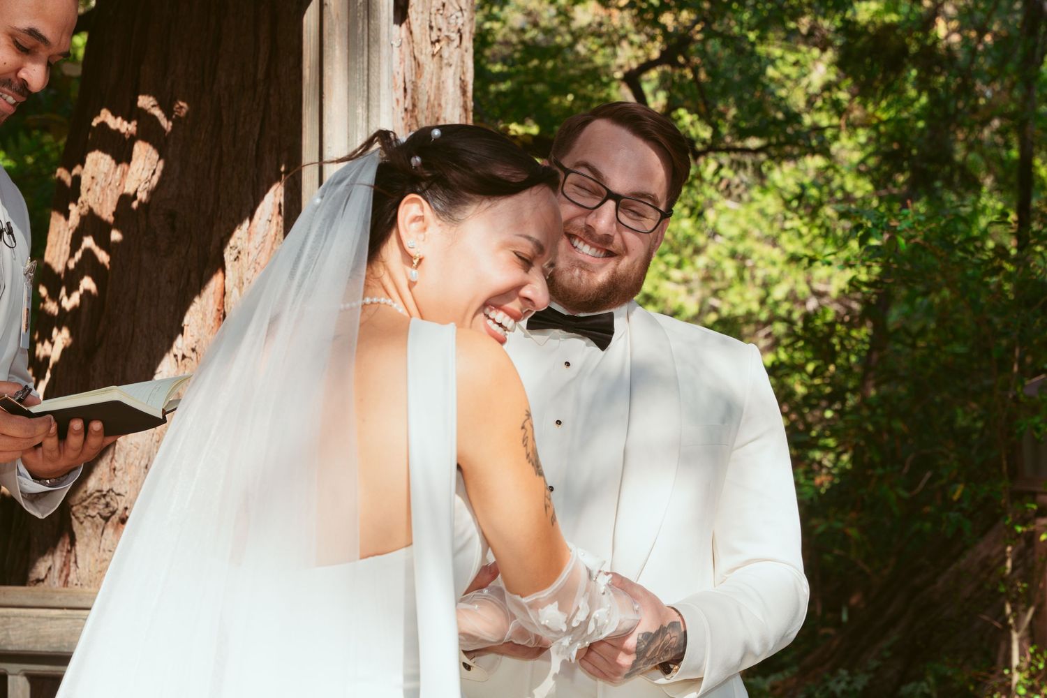 Joyful wedding moment shared between couple during outdoor garden ceremony.