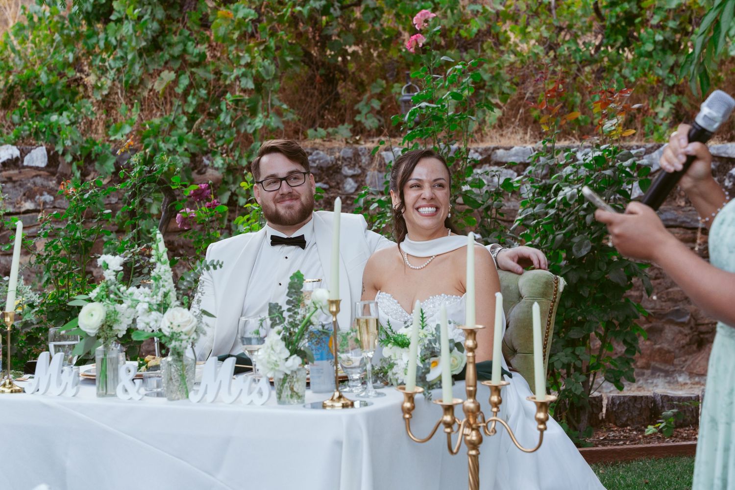Elegant wedding reception table setup with candelabras and floral arrangements outdoors.