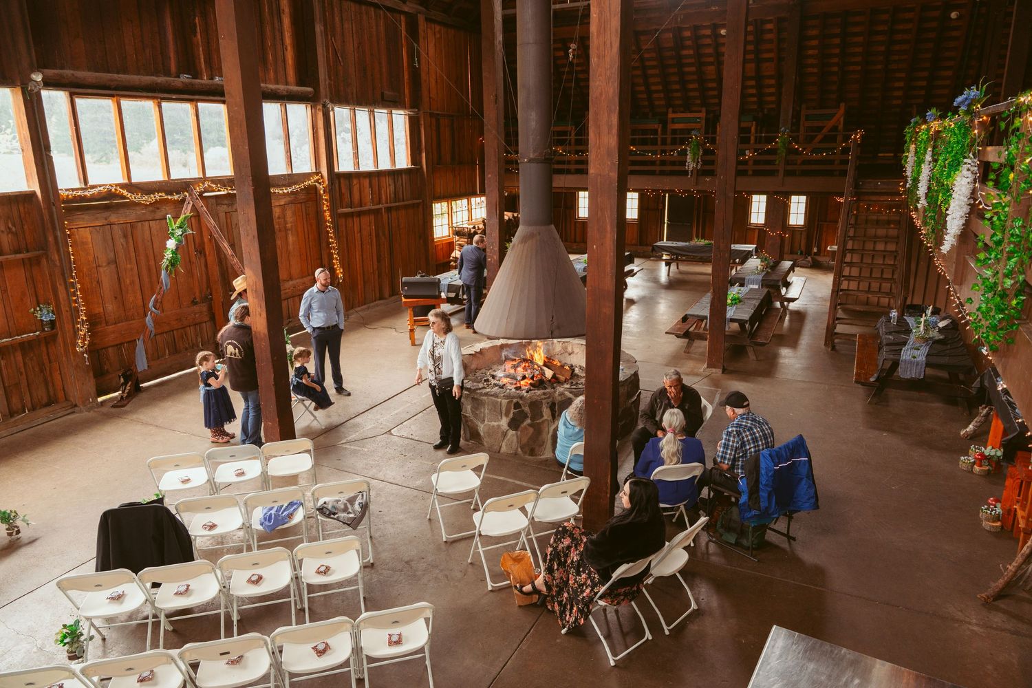 Spacious wooden event venue with rows of chairs and natural lighting from windows.