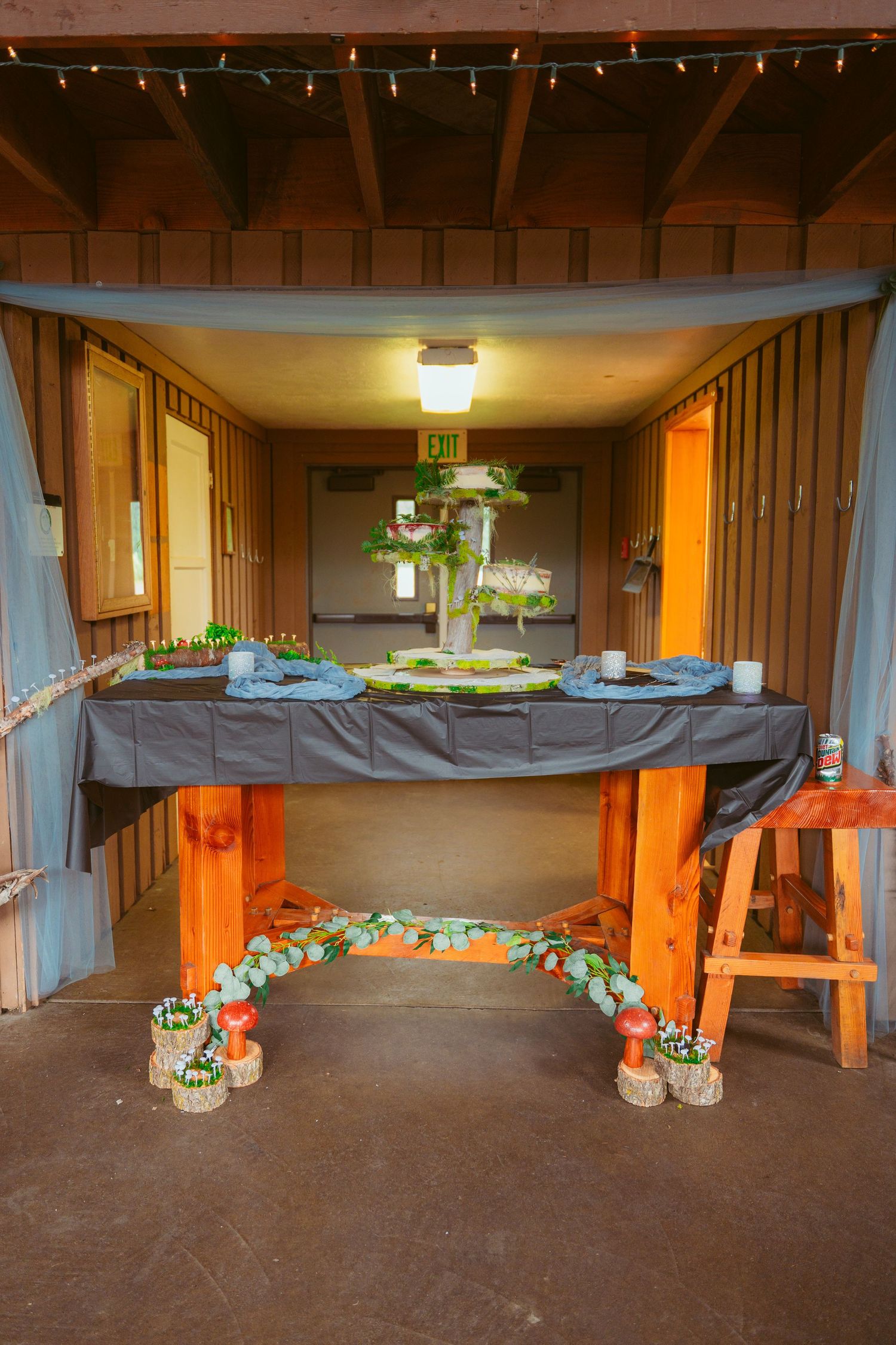 Interior of barn wedding venue with string lights and floral decorations.