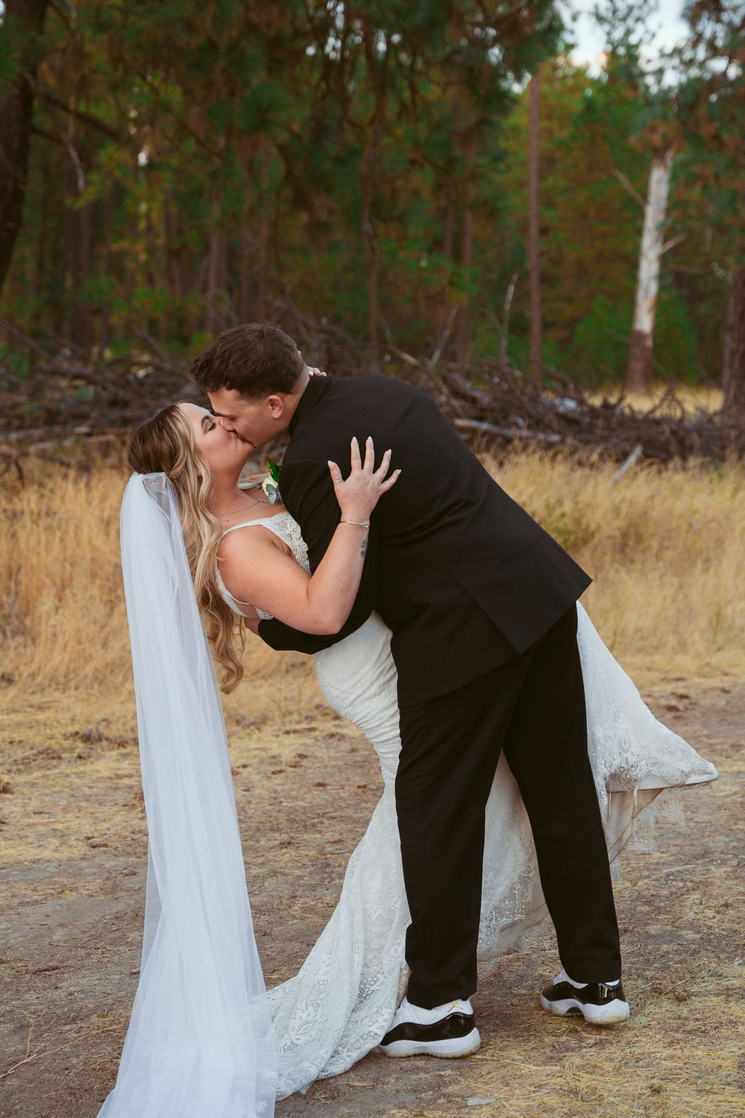 Romantic wedding dip pose captured in a series of photos with a forest backdrop.