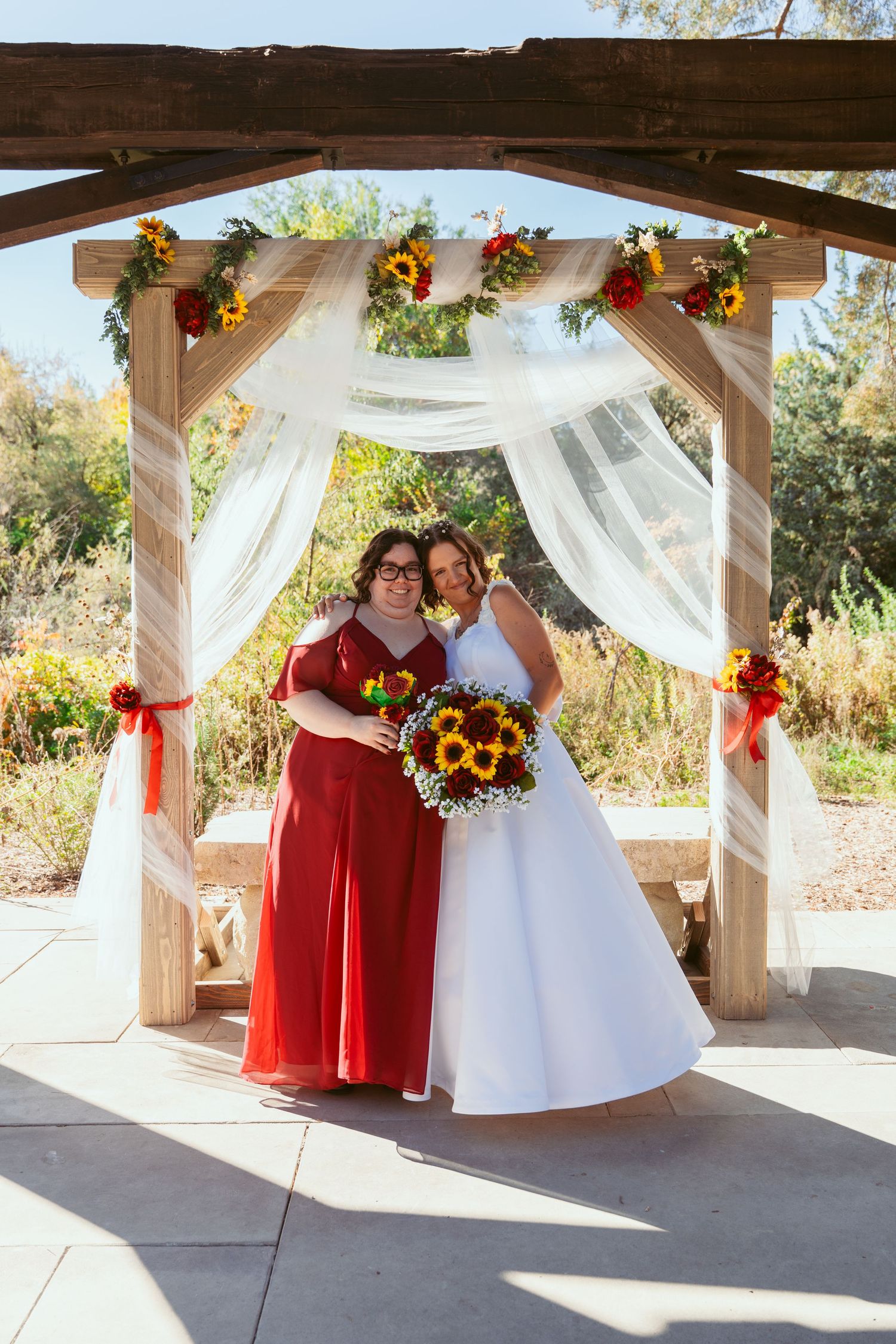 Wedding celebration photos under rustic wooden pergola with sunflower bouquets and white draping.