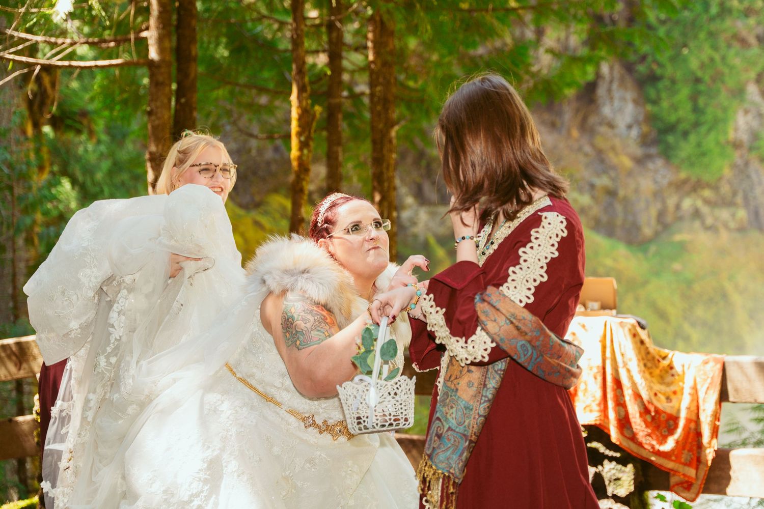 A wedding ceremony in progress with attendees in medieval fantasy costumes in a forest setting.