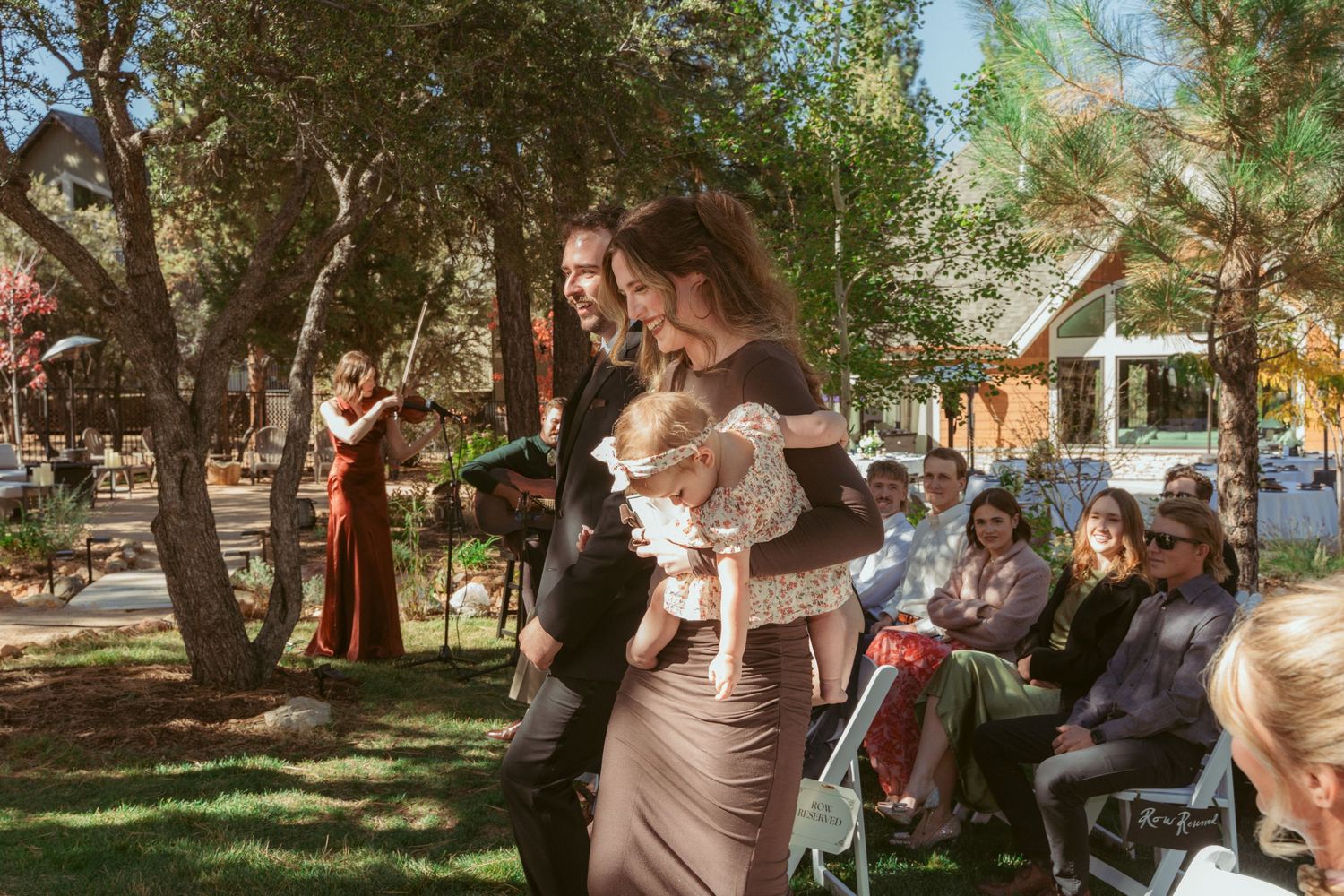 Wedding celebration taking place in a scenic outdoor garden setting with natural lighting.