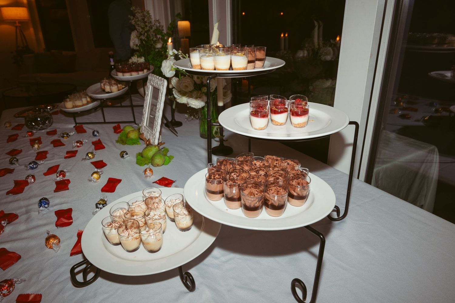 Elegant dessert display featuring chocolate truffles and pastries on tiered white platters.