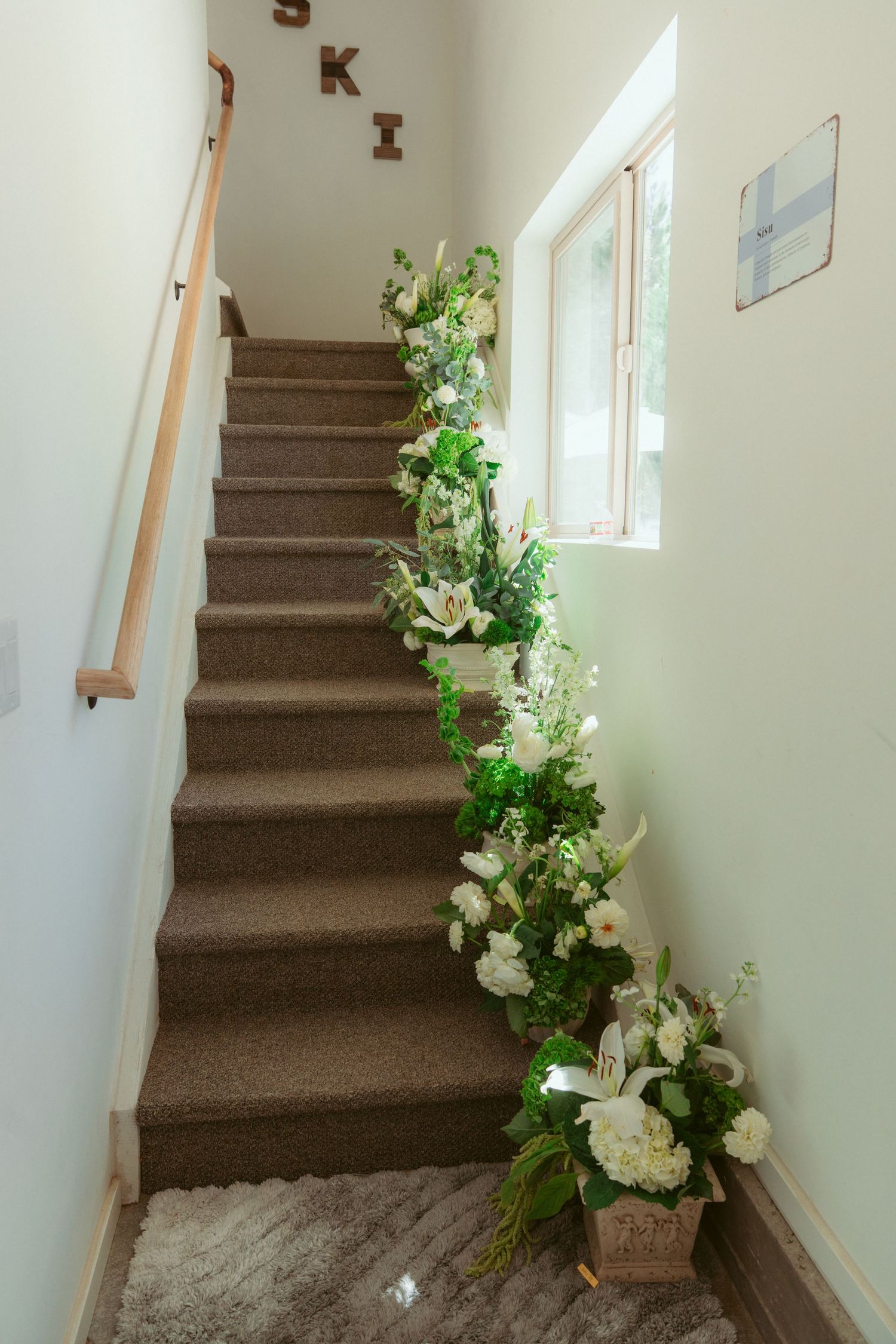 Elegant staircase decorated with white flowers and greenery for a wedding ceremony.