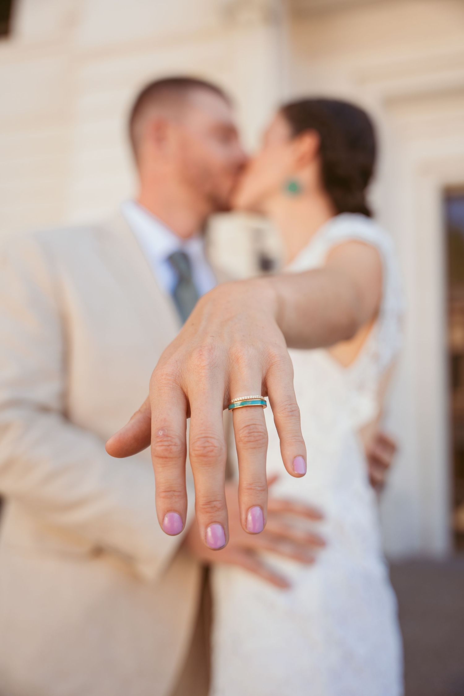 Close-up of hands showing off wedding rings with one hand wearing purple nail polish.