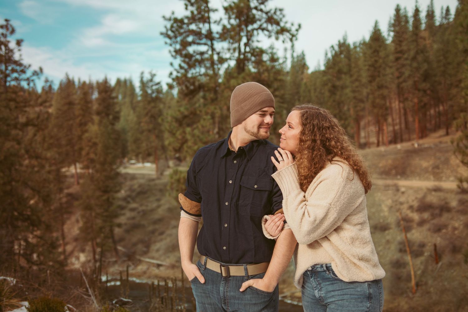 Couple enjoying a romantic moment outdoors with mountain scenery.