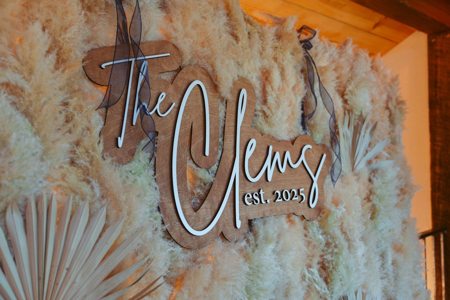 Decorative script signage mounted on textured wall with artistic pattern background.