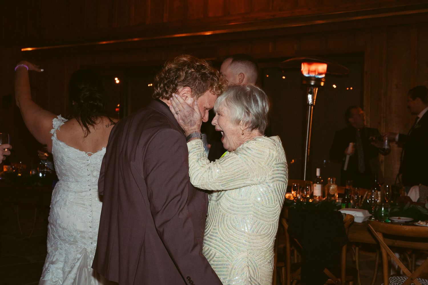 Couples dancing together at an evening wedding reception under warm lighting.