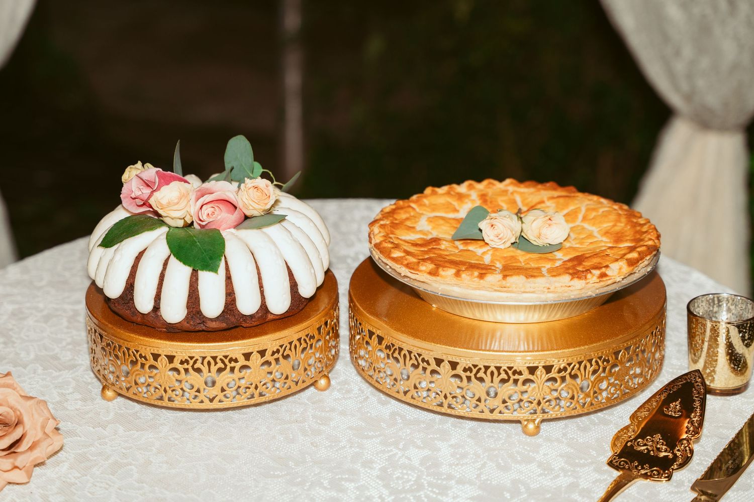 Beautifully decorated wedding cakes displayed on gold stands with intricate designs.