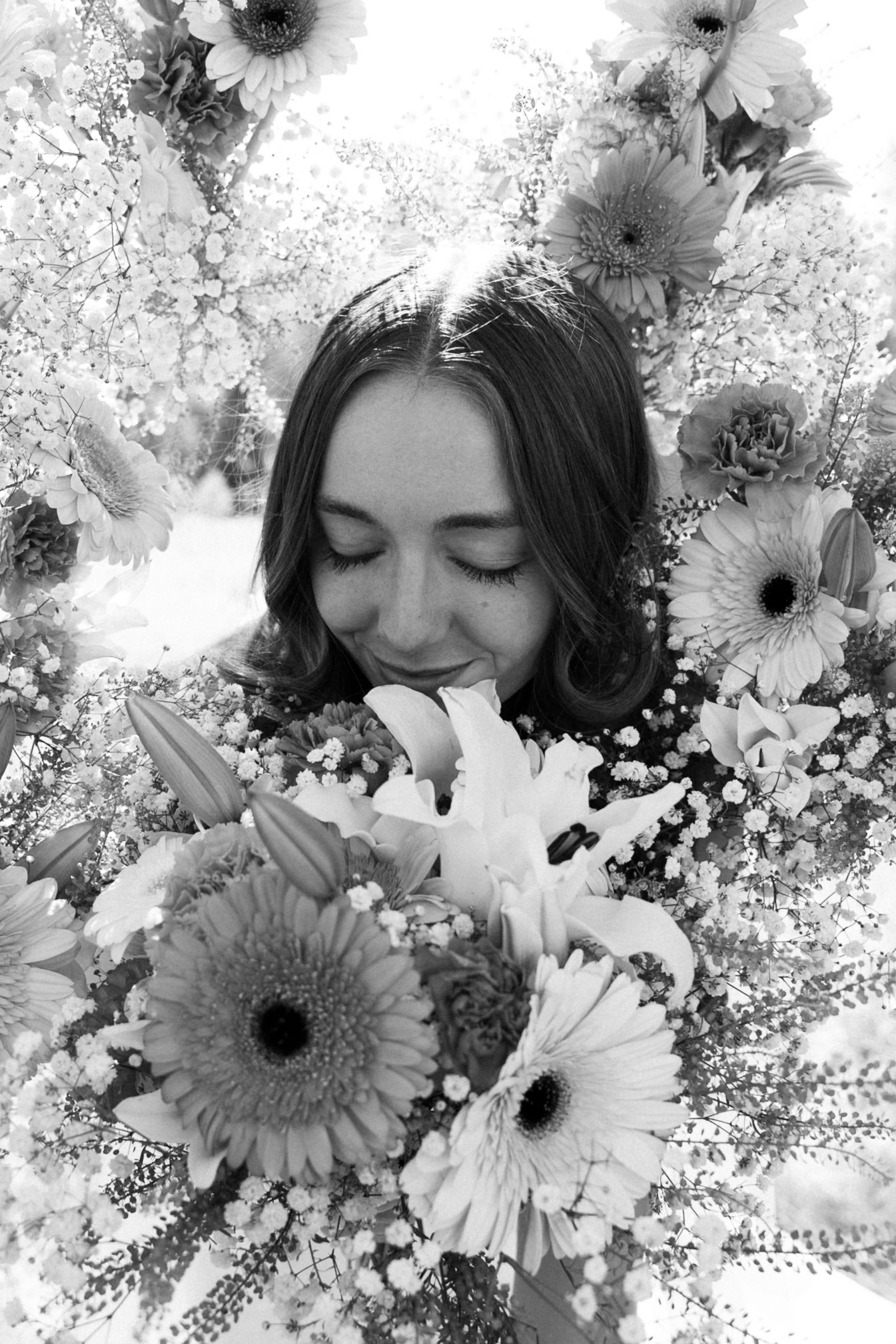 Artistic black and white portrait with soft floral overlays creating a dreamy effect.