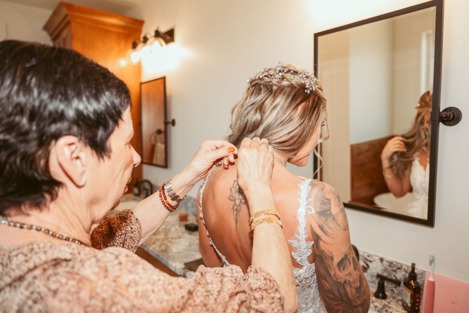 Wedding preparation scene showing final touches of jewelry and accessories in warm lighting.