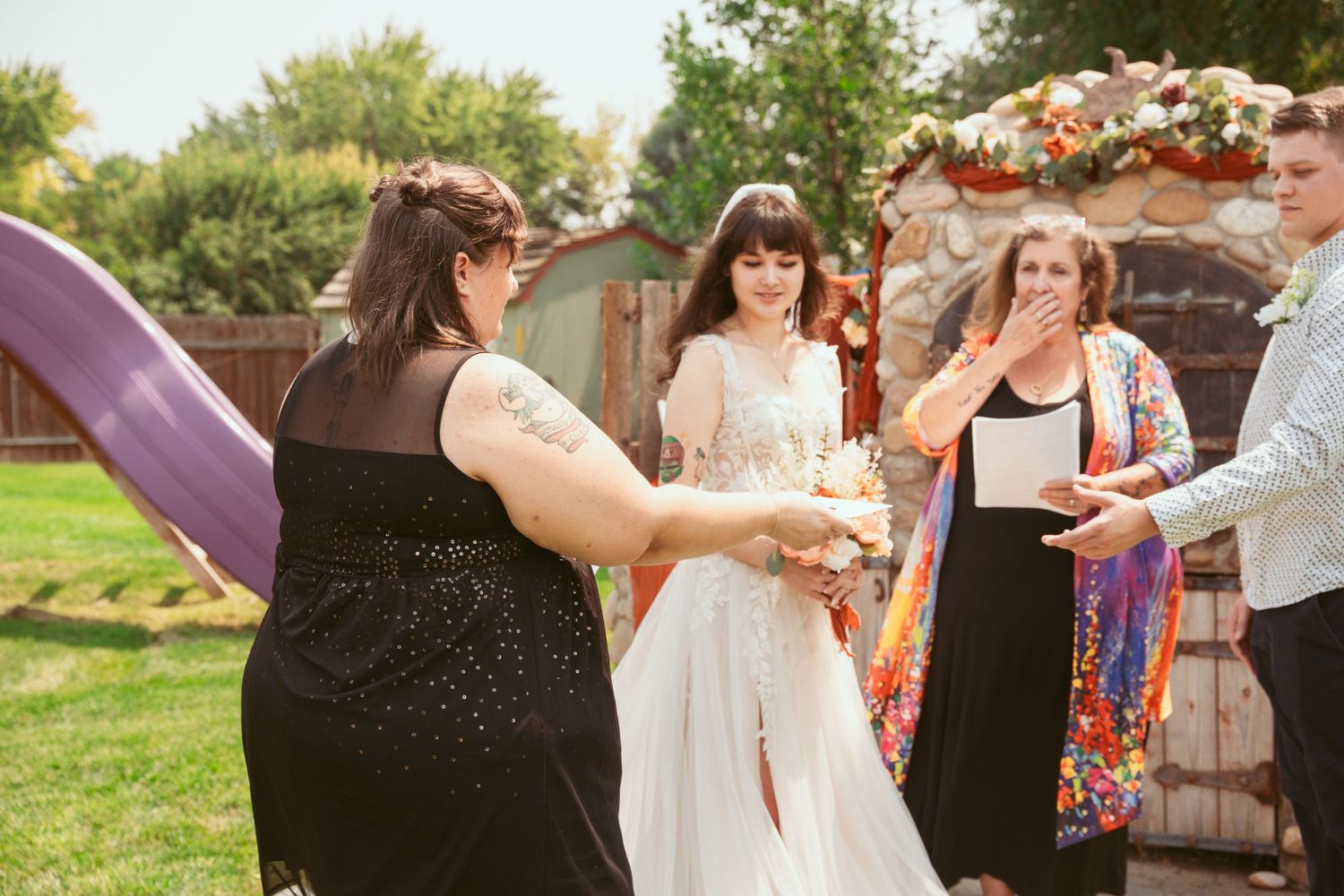 Wedding party members gathered outdoors during a sunny celebration.
