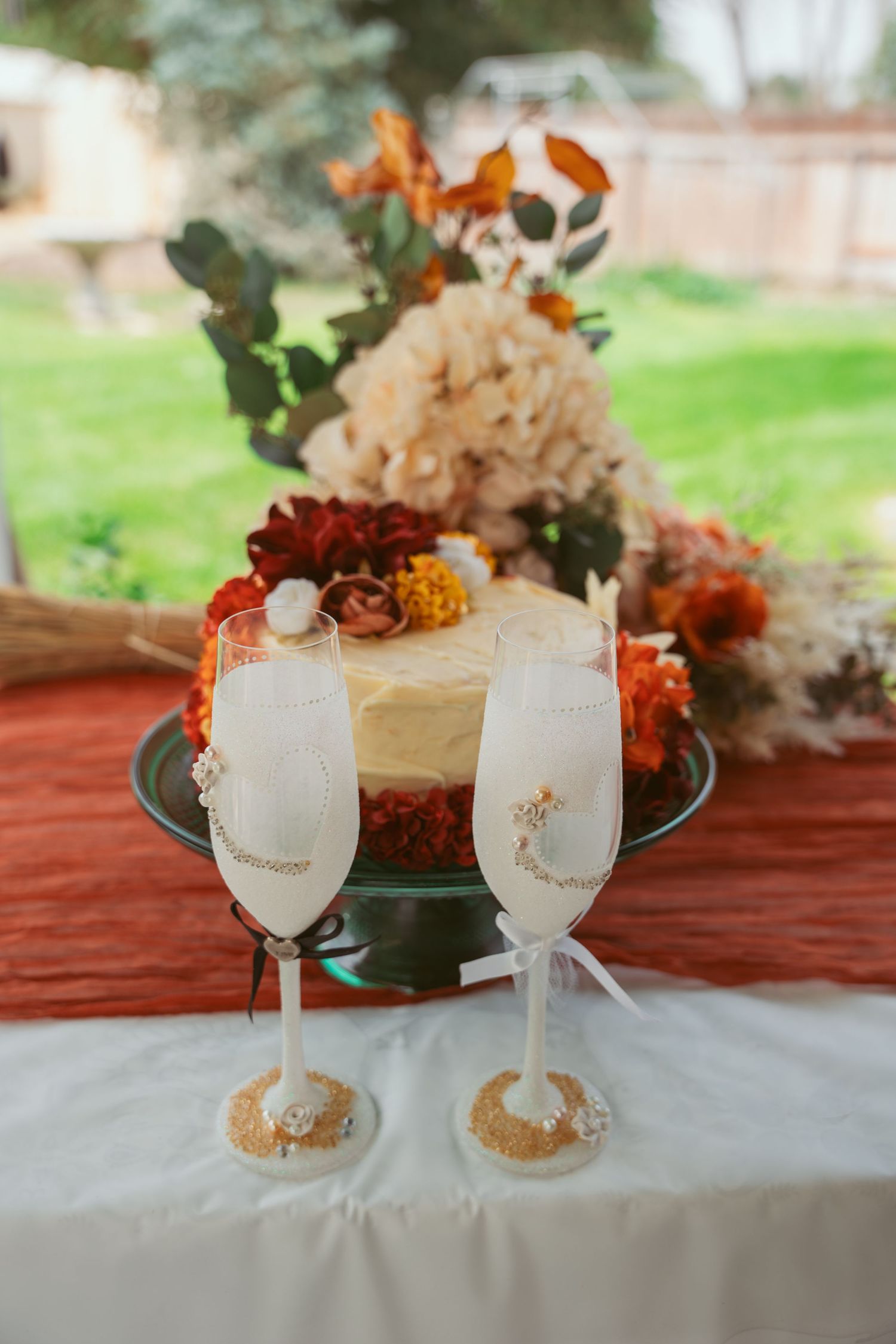 Elegant table setting with decorated wine glasses and autumn floral arrangements.