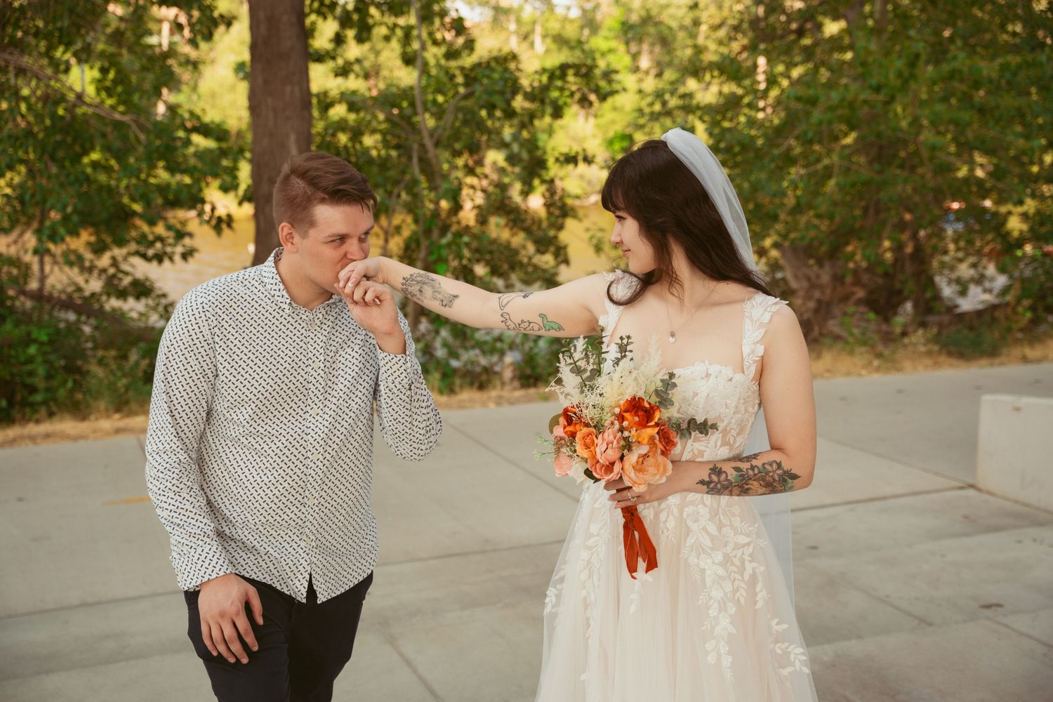 A sweet moment between newlyweds with autumn colors and orange bouquet.