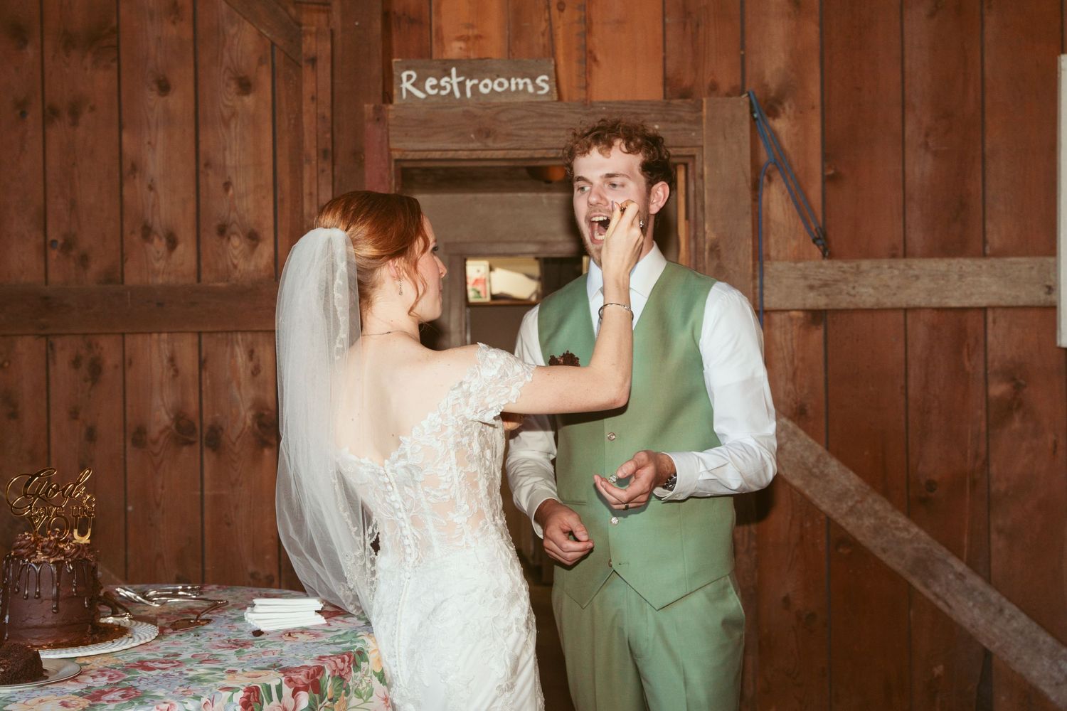Wedding celebration in a wooden barn decorated with romantic string lights and paper lanterns.