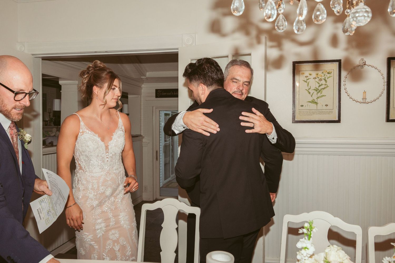 Emotional moment shared between wedding guests during indoor reception.