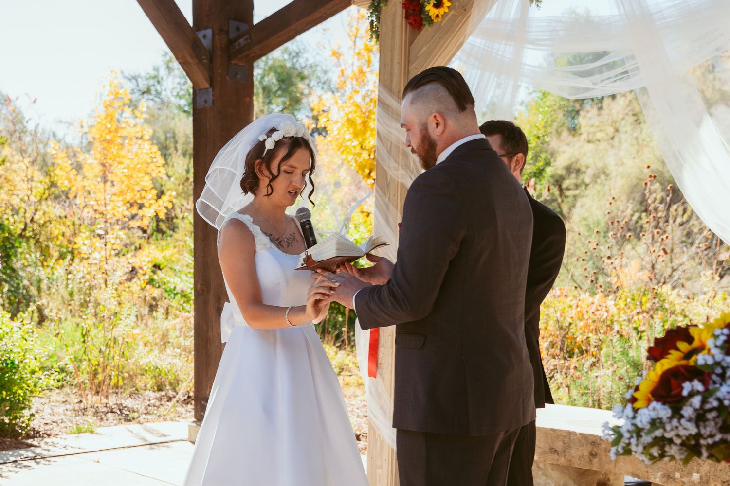 Intimate wedding ceremony moment captured under wooden beams with natural lighting.