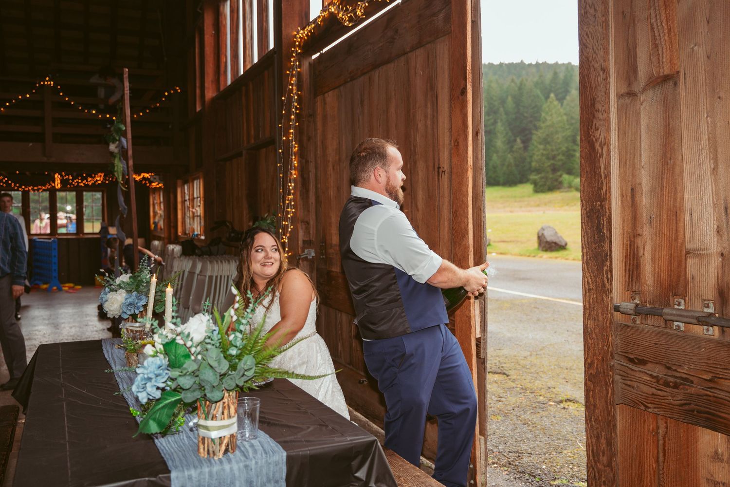 Barn wedding venue interior showing wooden walls, string lights and decorative elements.
