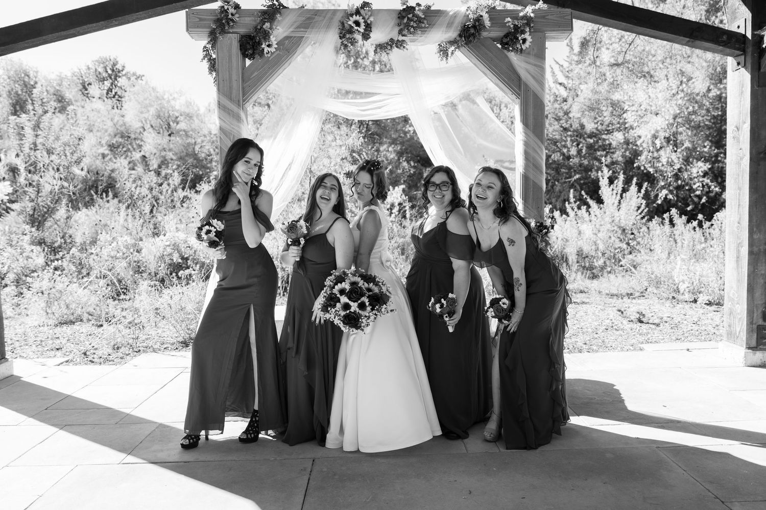 Black and white wedding party photos showing candid moments under covered pavilion.