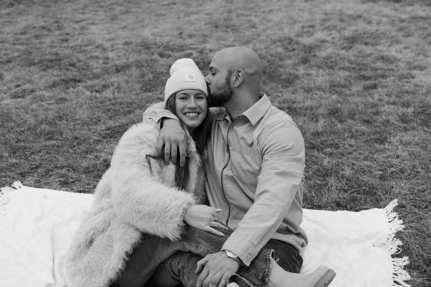 Black and white series of intimate couple moments captured on white blanket outdoors.